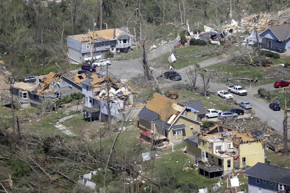 Fallen trees and damaged homes line a street Tuesday, April 14, 2020, in Chattanooga, Tenn. Tornadoes went through the area Sunday, April 12. (AP Photo/Mark Humphrey)