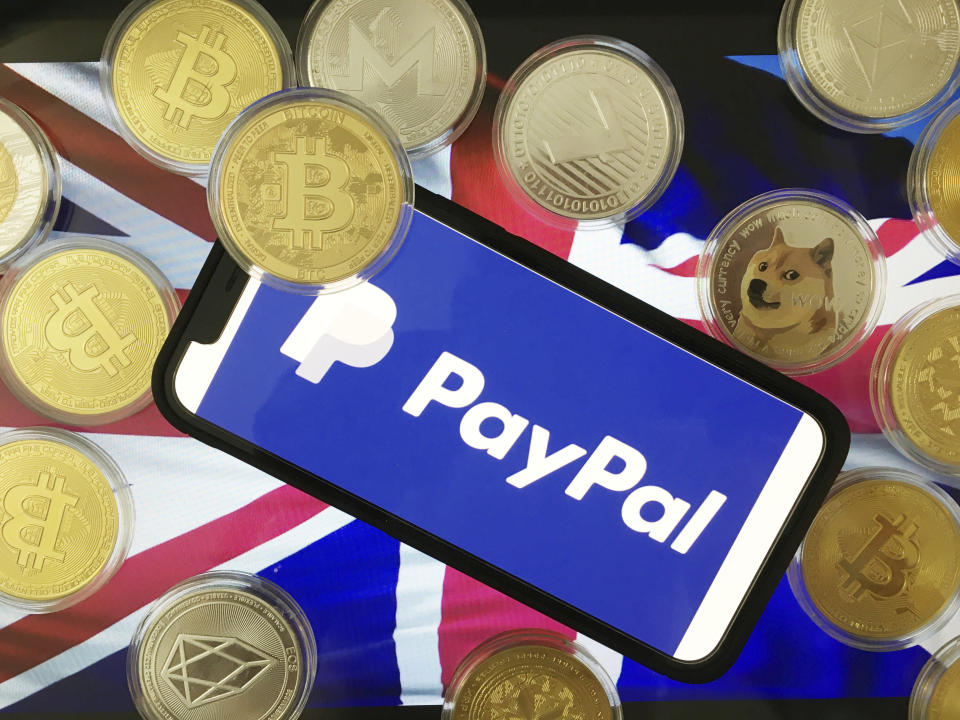 A stylised image of a phone, displaying the PayPal image, with various cryptocurrencies and the Union Jack flag. Source: AP