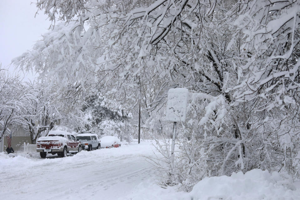 Street signs are covered in snow in north Flagstaff, Ariz., Friday, Nov. 29, 2019. A powerful storm making its way east from California is threatening major disruptions during the year's busiest travel weekend, as forecasters warned that intensifying snow and ice could thwart millions across the country hoping to get home after Thanksgiving. The storm has already killed at least one person and shut down highways in the western U.S., stranding drivers in California and prompting authorities in Arizona to plead with travelers to wait out the weather before attempting to travel. (Cody Bashore/Arizona Daily Sun via AP)