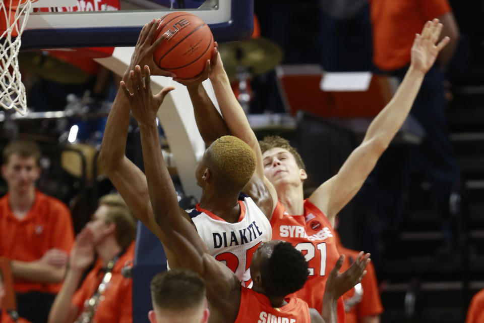 Syracuse forward Bourama Sidibe, bottom,, and forward Marek Dolezaj (21) try to block the shot of Virginia forward Mamadi Diakite (25) during the first half of an NCAA college basketball game in Charlottesville, Va., Saturday, Jan. 11, 2020. (AP Photo/Steve Helber)