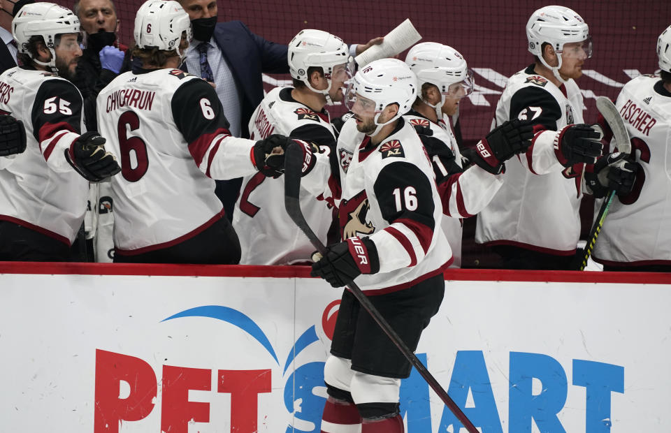 Arizona Coyotes center Derick Brassard, front, is congratulated as he passes the team box after scoring a goal against the Colorado Avalanche in the first period of an NHL hockey game Monday, March 8, 2021, in downtown Denver. (AP Photo/David Zalubowski)