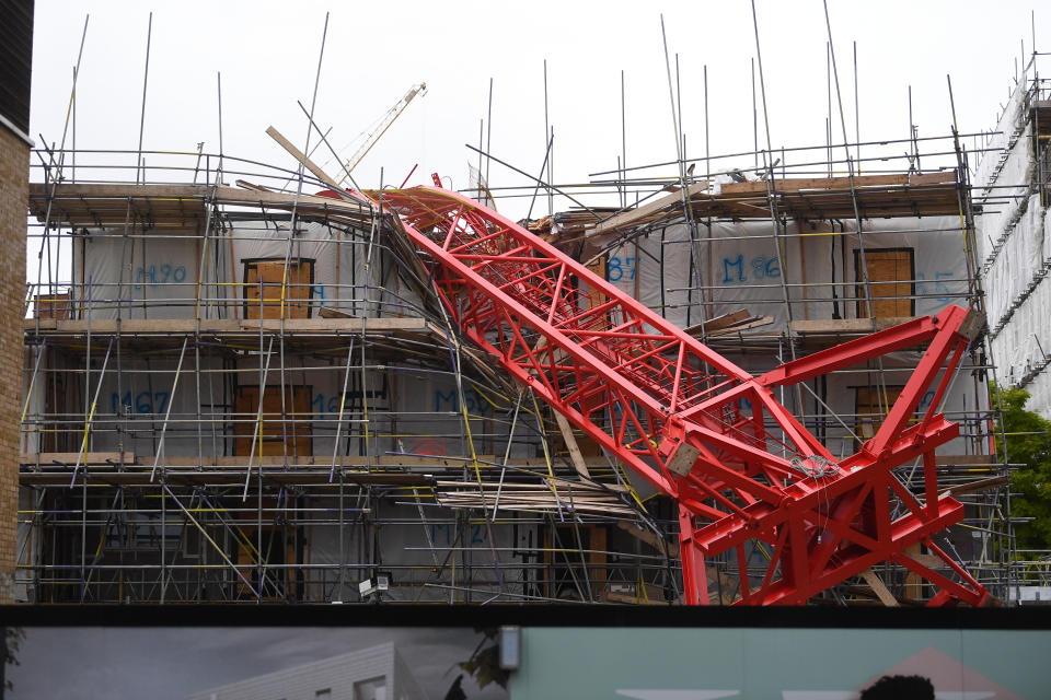 Emergency personnel at the scene in Bow, east London, where a 20-metre crane has collapsed on to a house leaving people trapped inside.