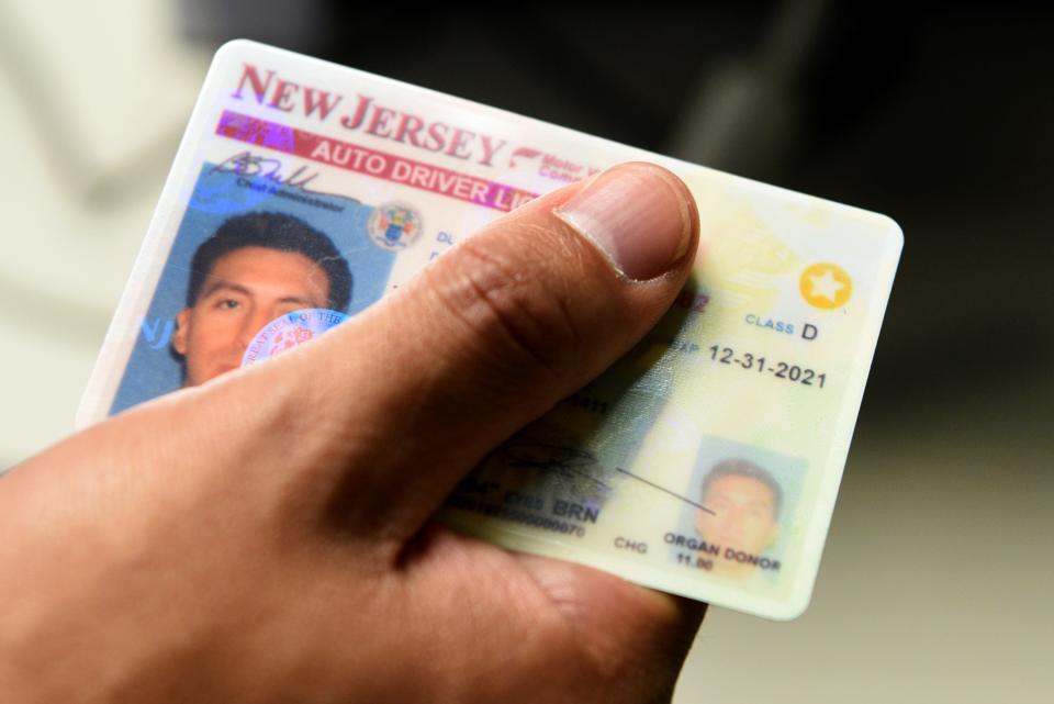 A New Jersey driver holds a Real ID card.