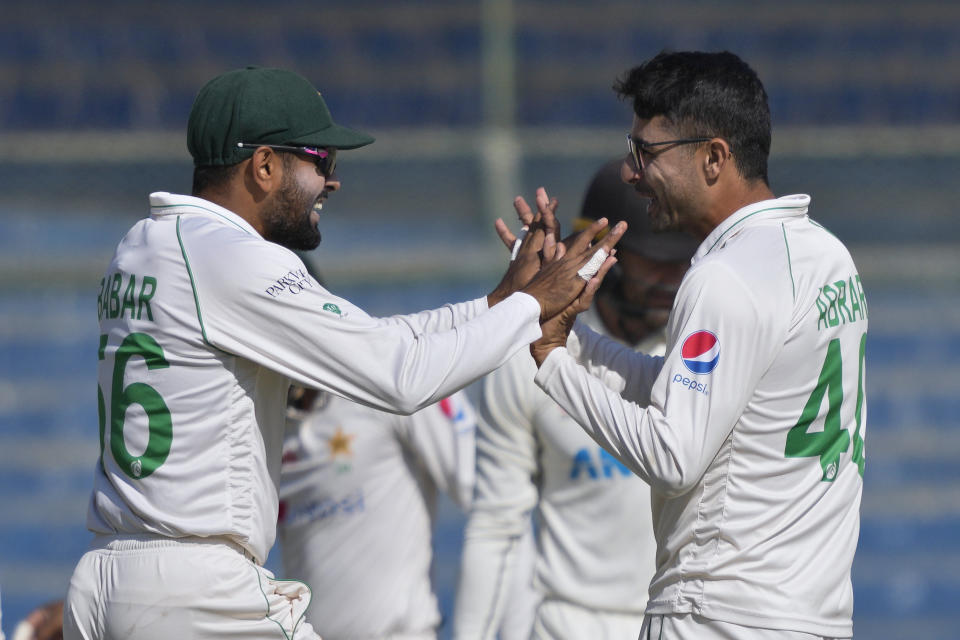 Pakistan's Abrar Ahmed, right, celebrates with Babar Azam after taking the wicket of New Zealand's Tom Blundell during the second day of the second test cricket match between Pakistan and New Zealand, in Karachi, Pakistan, Tuesday, Jan. 3, 2023. (AP Photo/Fareed Khan)