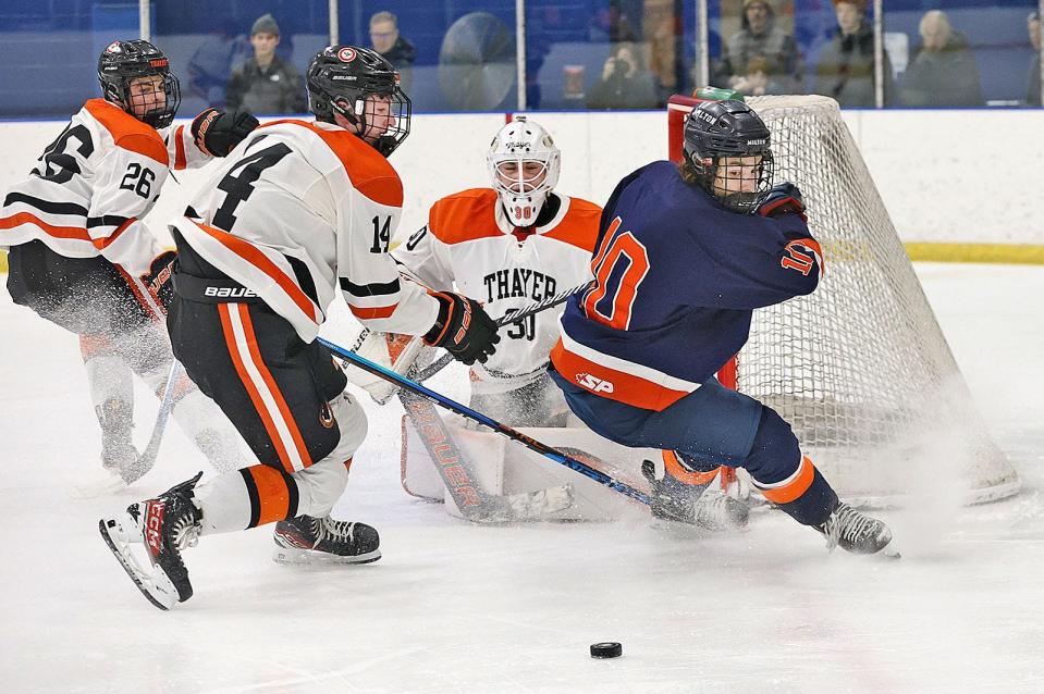 Milton Academy captain Will Cannata watches the puck to pick up a rebound of his shot while being covered by Thayer's #14 Matty MacDonald of Walpole.

Milton Academy hosts Thayer Academy in boys hockey on Friday Feb. 16, 2024