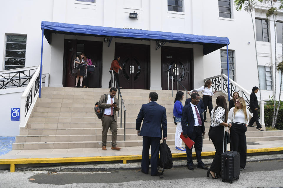 Abogados y funcionarios judiciales salen de la Suprema Corte en un receso del juicio por lavado de dinero de los Panamá Papers en Ciudad de Panamá, el lunes 8 de abril de 2024. (AP Foto/Agustín Herrera)