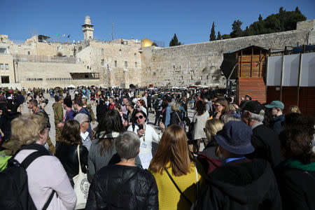 The tour guide, Noor Awad, a Palestinian from Bethlehem, speaks to tourists, during the Dual Narrative tour he leads together with his colleague Lana Zilberman Soloway, a Jewish seminary student, as they stand next to the Western Wall, Judaism's holiest prayer site in Jerusalem's Old City, February 4, 2019. REUTERS/Ammar Awad/Files