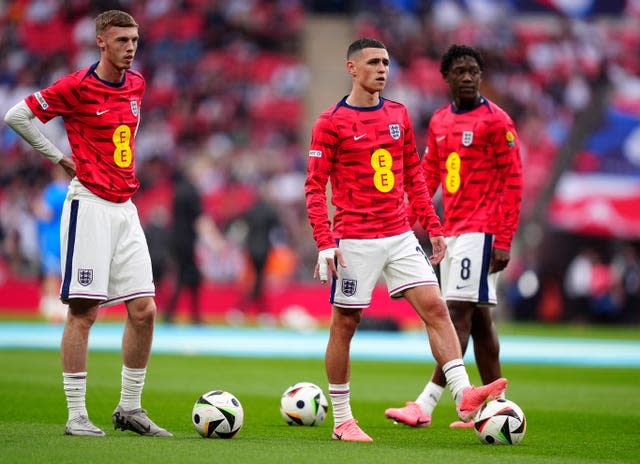 England’s Cole Palmer, Phil Foden and Kobbie Mainoo, left to right,  warming up before the friendly against Iceland in June