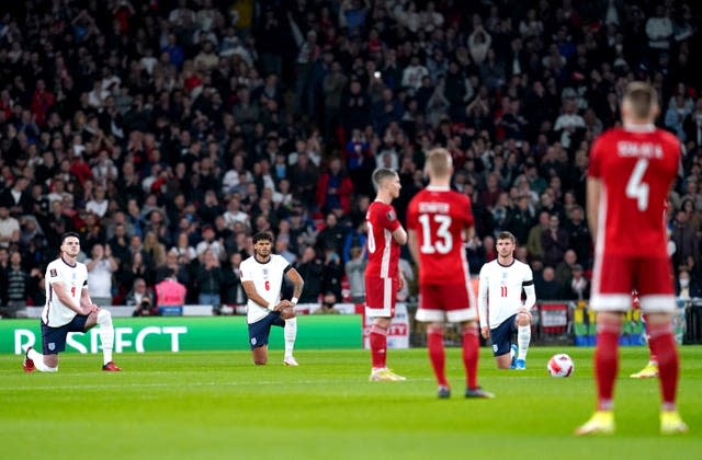 Tyrone Mings, centre, and England take a knee while Hungary remain standing