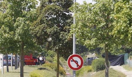 French Gendarmes and rescue forces stand near a black plastic sheet (R) outside a gas company site at the industrial area of Saint-Quentin-Fallavier, outside Lyon, France, June 26, 2015. REUTERS/Emmanuel Foudrot