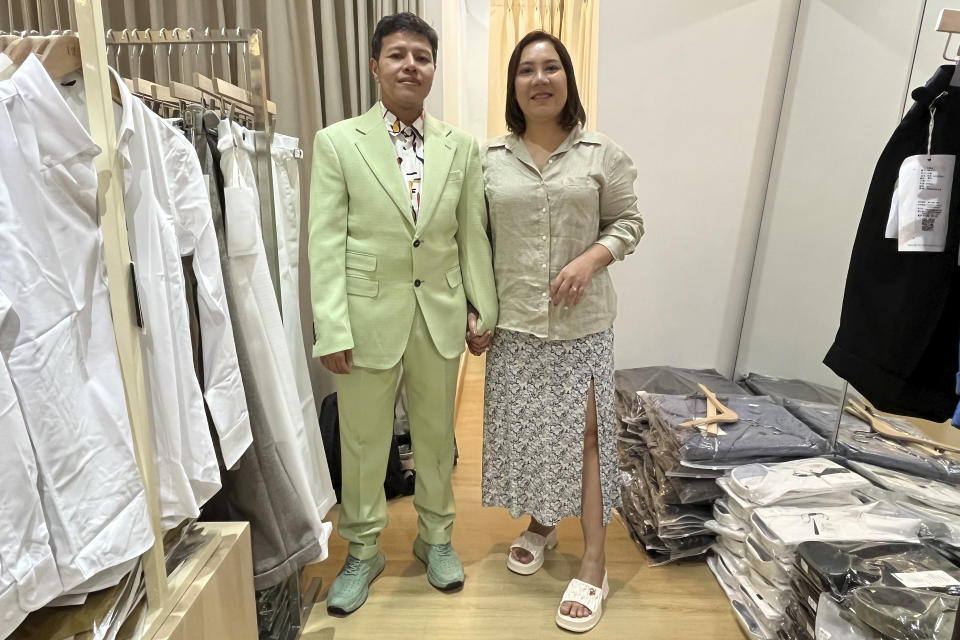 An LGBTQ couple Naphat Krutthai, a transgender man, left, and Rasithaya Jindasri, pose for a photo as Naphat tried on a suit while he was shopping for clothes in Bangkok, Thailand, Tuesday, Dec. 5, 2023. Thailand's Parliament is set to debate Thursday, Dec. 21, a final cabinet-endorsed draft bill to pass landmark legislation allowing members of the LGBTQ+ community to get married. (AP Photo/Sakchai Lalit)