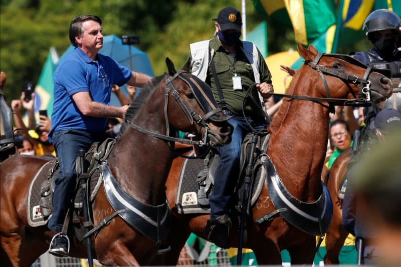 Brazil's President Jair Bolsonaro rides a horse during a meeting with supporters protesting in his favor, amid the coronavirus disease (COVID-19) outbreak, in Brasilia