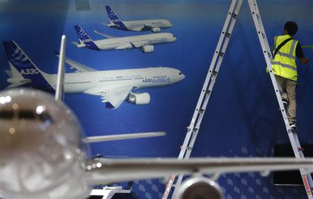 A worker makes final touches to the Airbus booth ahead of the Singapore Airshow February 10, 2014. REUTERS/Edgar Su