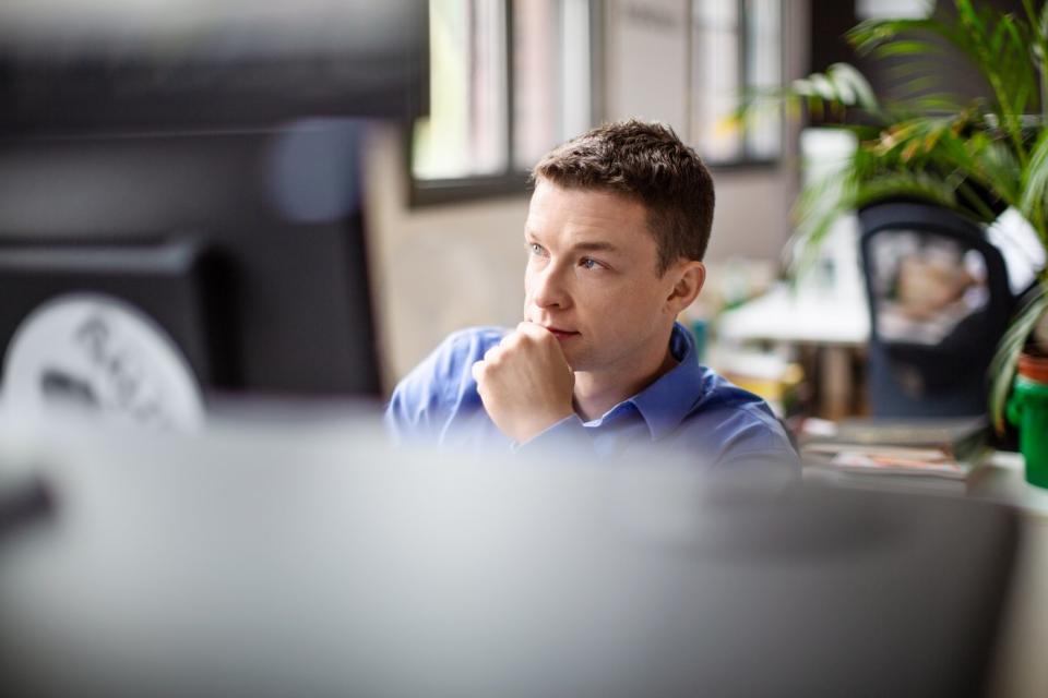 An investor looks pensive while sitting at a computer.