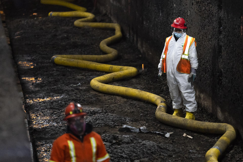 Amtrak workers perform tunnel repairs to a partially flooded train track bed, Saturday, March 20, 2021, in Weehawken, N.J. With a new rail tunnel into New York years away at best, Amtrak is embarking on an aggressive and expensive program to fix a 110-year-old tunnel in the interim. (AP Photo/John Minchillo)