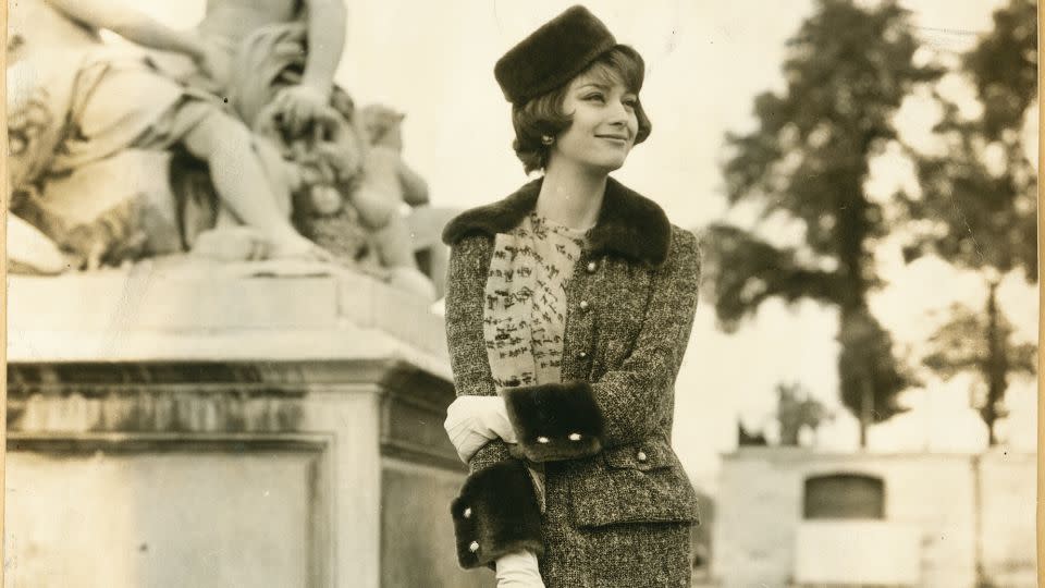 Model and actress Marie-Hélène Arnaud in a tweed suit from Chanel’s Fall-Winter 1959 collection and Chanel shoes, carrying the house's iconic 2.55 handbag. - Chanel/Courtesy V&A