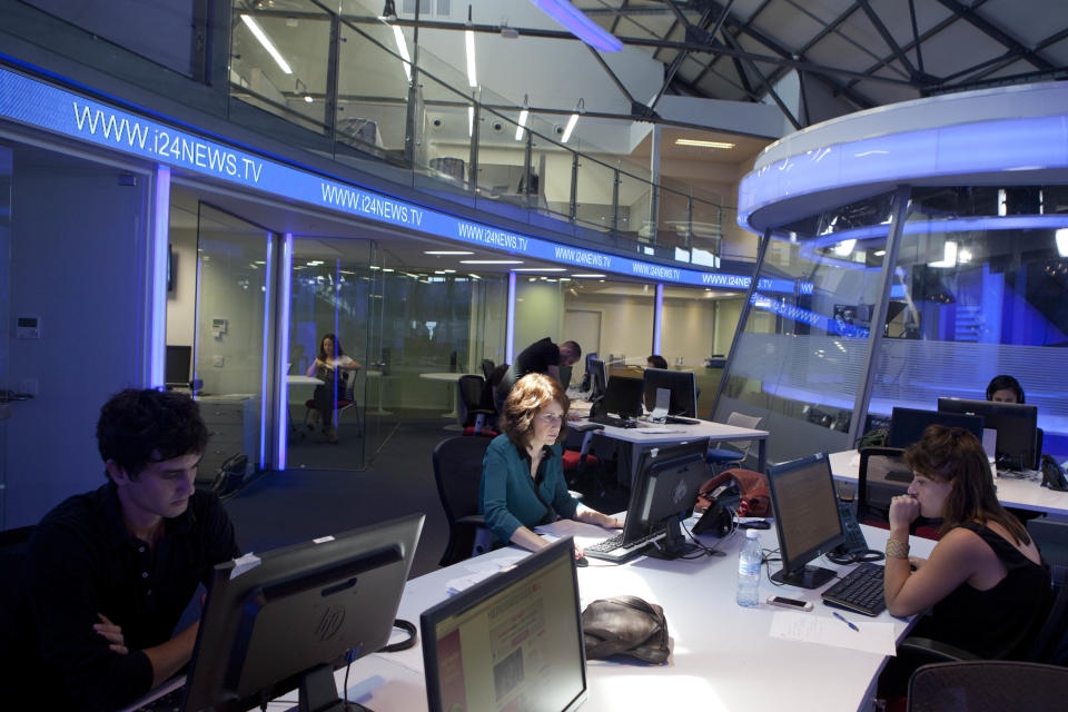 In this Sunday, July 28, 2013 photo, journalists work inside a studio of the new television channel I24news in Tel Aviv, Israel. The station's founders insist they are not an Israeli version of Al-Jazeera, the powerful broadcaster from the Gulf. They say they receive no government funding, hold no political affiliation and pledge to cover the news dispassionately and objectively. (AP Photo/Dan Balilty)