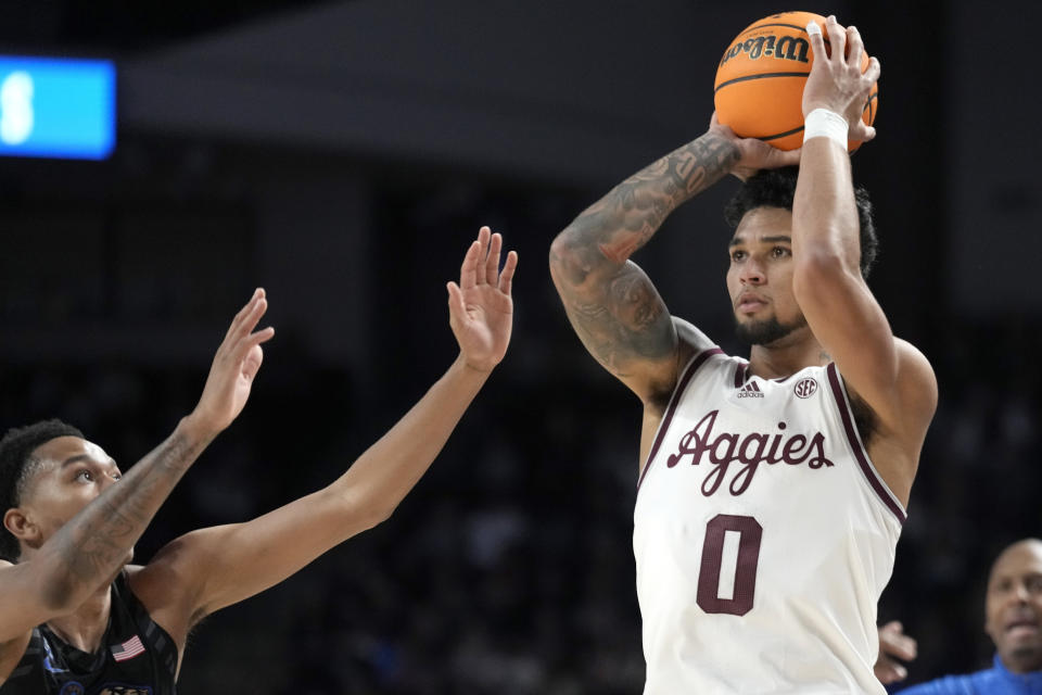 Texas A&M guard Jace Carter (0) looks to shoot a 3-point basket as Memphis forward Ashton Hardaway, left, is late to defend during the first half of an NCAA college basketball game Sunday, Dec. 10, 2023, in College Station, Texas. (AP Photo/Sam Craft)