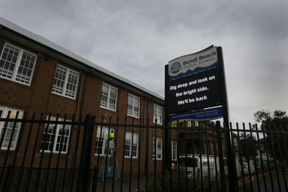 A public sign displays messages outside Bondi Beach Public School in Sydney, Australia.