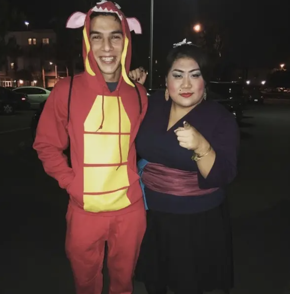 One person wearing red sweats with a hood as a dragon's mouth, and another dressed as the Matchmaker from "Mulan"