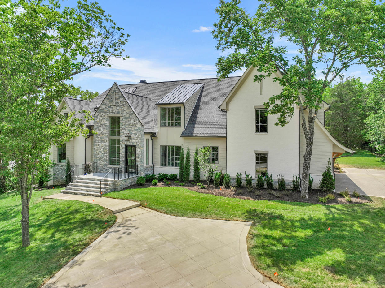 The front facade of 649 Brook Hollow Road features stonework and white brick.