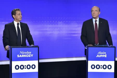French politicians Nicolas Sarkozy (L) and Alain Juppe attend the final prime-time televised debate for the French center-right presidential primary in Paris, France, November 17, 2016. REUTERS/Christphe Archambault/Pool