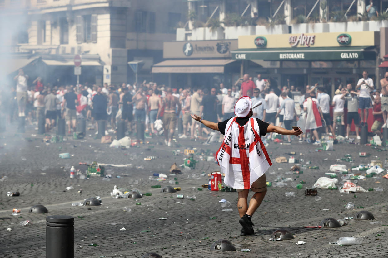 MARSEILLE, FRANCE - JUNE 11:  A fan wears the Englad flag colors as rubbish lines the streets as England fans gather, cheer and clash with police ahead of the game against Russia later today on June 11, 2016 in Marseille, France.  Football fans from around Europe have descended on France for the UEFA Euro 2016 football tournament.  (Photo by Carl Court/Getty Images)