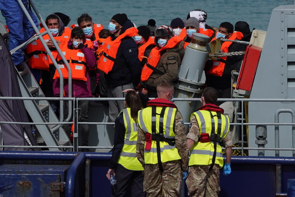 A group of people thought to be migrants are brought in to Dover, Kent, England, by the RNLI, following a small boat incident in the Channel, Thursday April 14, 2022. Britain's Conservative government has struck a deal with Rwanda to send some asylum-seekers thousands of miles away to the East African country. Opposition politicians and refugee groups are condemning the plan as unworkable, inhumane and a waste of public money. (Gareth Fuller/PA via AP)