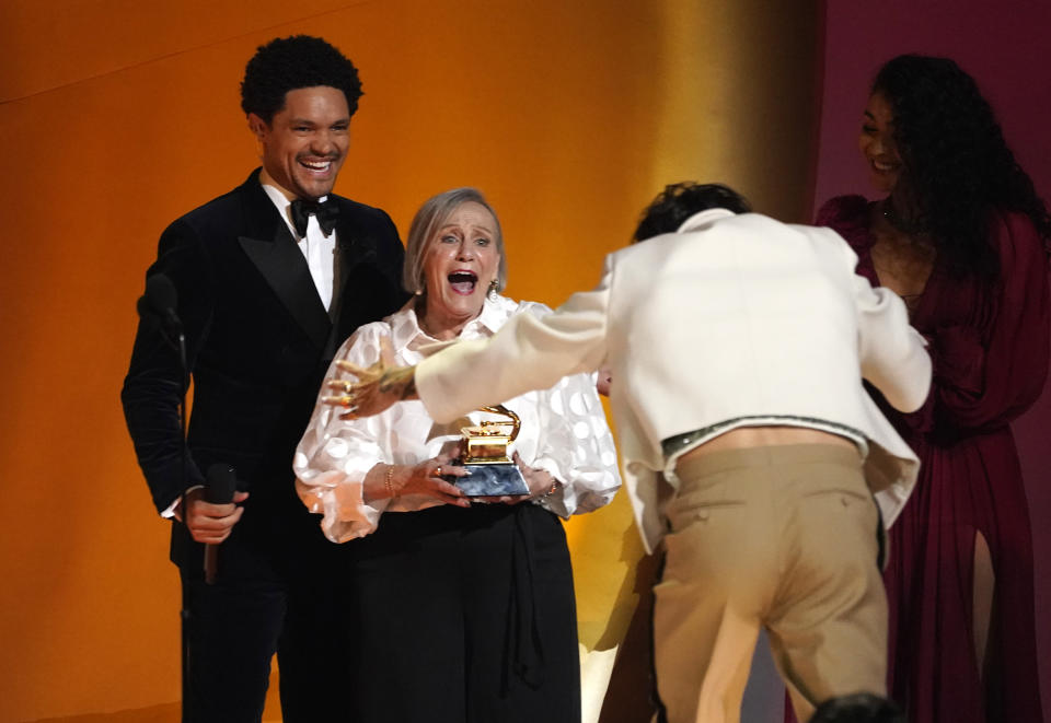Harry Styles fan, Reina Fafantaisie, center, presents Harry Styles, right, with the award for album of the year for "Harry's House" at the 65th annual Grammy Awards on Sunday, Feb. 5, 2023, in Los Angeles. Host Trevor Noah looks on from left. (AP Photo/Chris Pizzello)