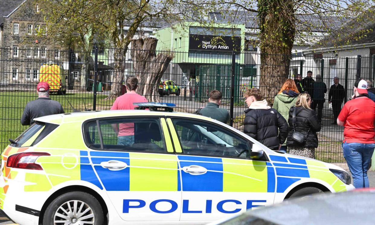 <span>Anxious parents and friends wait outside Ysgol Dyffryn Aman in Carmarthenshire as the school was locked down on Wednesday. </span><span>Photograph: Robert Melen/Rex/Shutterstock</span>