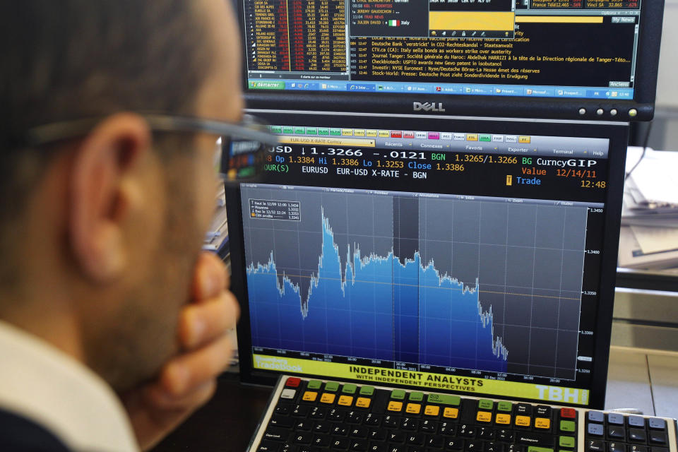 A stock trader checks out a graph showing activity of the euro currency against the US dollar in a business bank, in Paris, Monday, Dec. 12, 2011. Enthusiasm for riskier assets such as stocks and the euro faded Monday as investors worried that Europe's new pact aimed at fixing the continent's debt crisis would be insufficient. (AP Photo/Michel Euler)