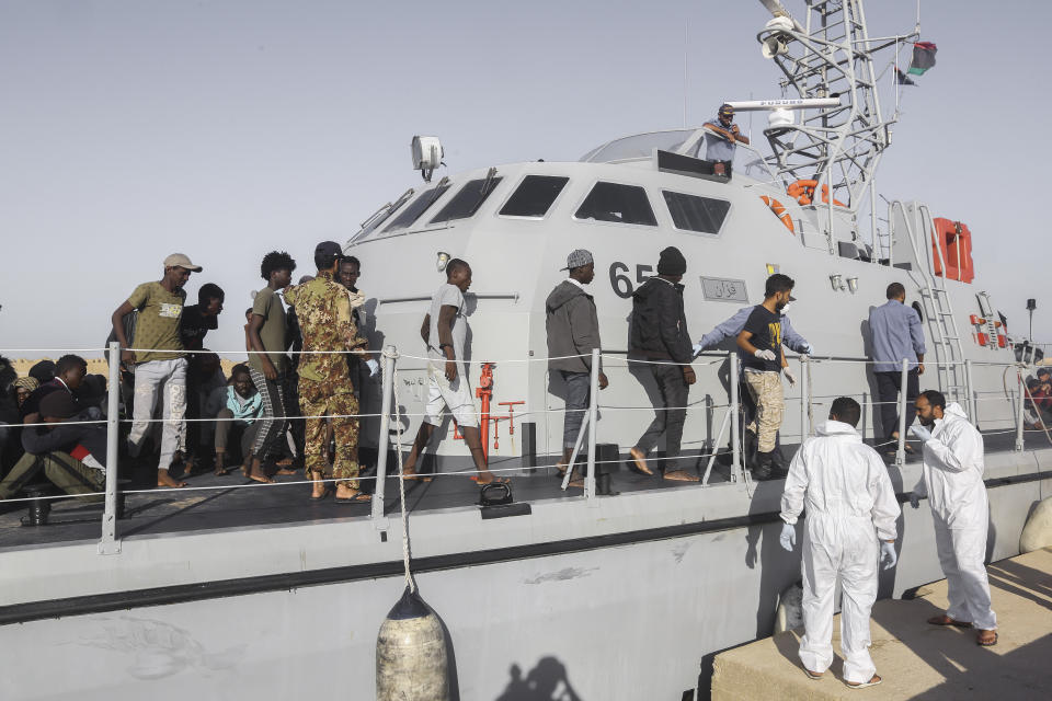 Rescued migrants walk off a coast guard boat in the city of Khoms, around 120 kilometers (75 miles) east of Tripoli, Libya, Tuesday, Oct. 1, 2019. (AP Photo/Hazem Ahmed)