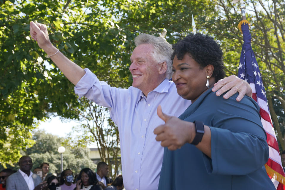 Voting rights activist Stacey Abrams, right, and Democratic gubernatorial candidate, former Virginia Gov. Terry McAuliffe, wave to the crowd during a rally in Norfolk, Va., Sunday, Oct. 17, 2021. Abrams was in town to encourage voters to vote for the Democratic gubernatorial candidate in the November election. (AP Photo/Steve Helber)