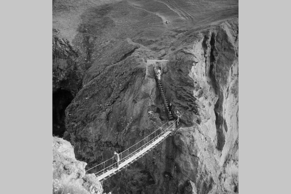 3rd April 1939:  A temporary rope bridge connects the tiny island of Carrick-a-Rede with the northern coast of County Antrim during the salmon fishing season.  (Photo by Fox Photos/Getty Images)