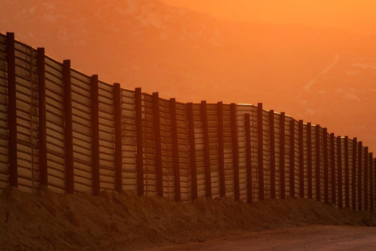 Dusk falls over a section of the US-Mexico border fence: David McNew/Getty Images