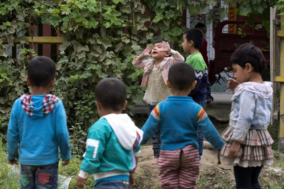 In this Aug. 30, 2018, photo, Uighur children play outdoors in Hotan, in western China's Xinjiang region. Uighurs fear the Chinese government's expansion of compulsory Mandarin-intensive classes and boarding schools away from home will gradually erode their children's Central Asian ethnic identity and Islamic beliefs. (AP Photo/Ng Han Guan)