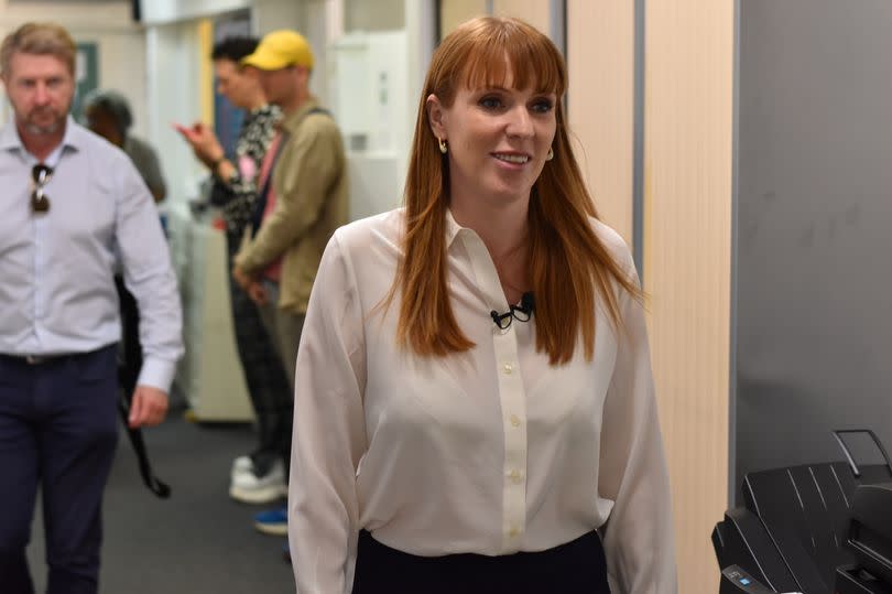 Angela Rayner walking in a white blowse