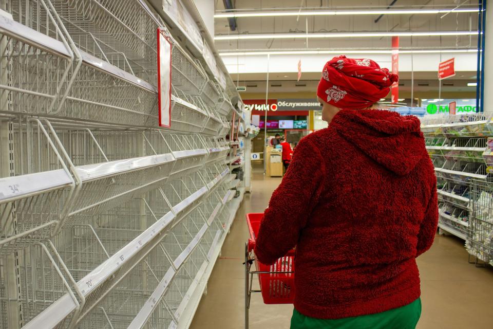 A woman walks by empty supermarket shelves in Moscow, Russia on March 23.