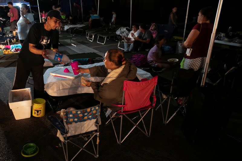 People rest at a makeshift camp outside their apartment building after an earthquake in Yauco