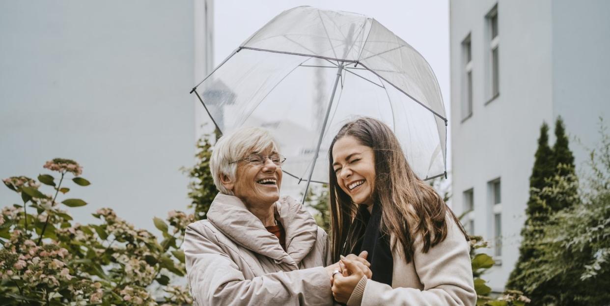 cheerful senior woman talking with female healthcare worker in park