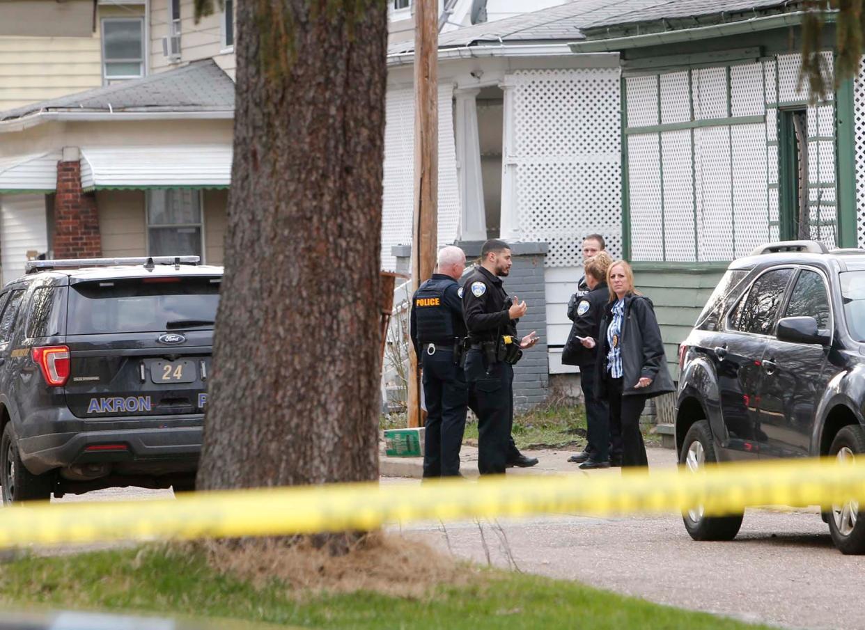 Akron police and members of the Summit County Medical Examiner's Office in the North Hill neighborhood of Akron on Thursday evening.