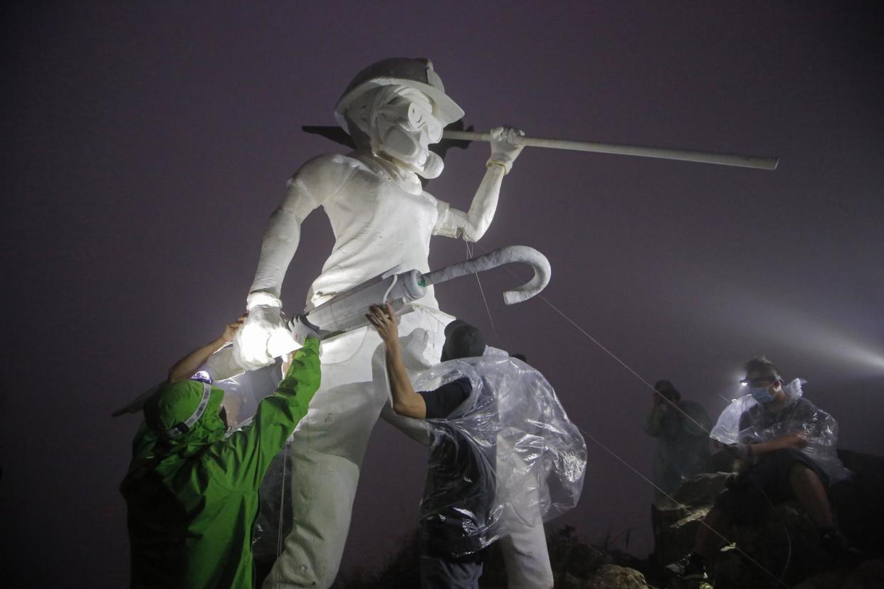 <span>Anti-government protesters set up a four-metre statue Lady Liberty of Hong Kong atop Lion Rock, one of Hong Kong's iconic peaks, in 2019. The artwork was destroyed the next day.</span><span>Photograph: Kin Cheung/AP</span>