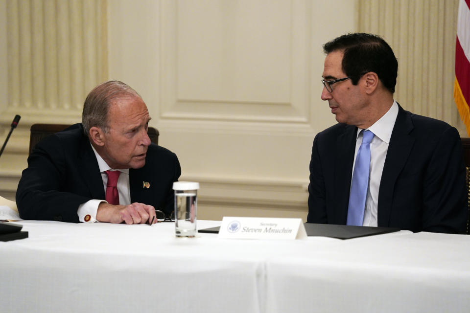 FILE - In this May 8, 2020, file photo Treasury Secretary Steven Mnuchin, right, talks with White House chief economic adviser Larry Kudlow prior to a meeting between President Donald Trump and Republican lawmakers in the State Dining Room of the White House in Washington. Some of Trump’s top economic advisers emphasized on Sunday, May 10, the importance of states getting more businesses and offices open. (AP Photo/Evan Vucci, File)