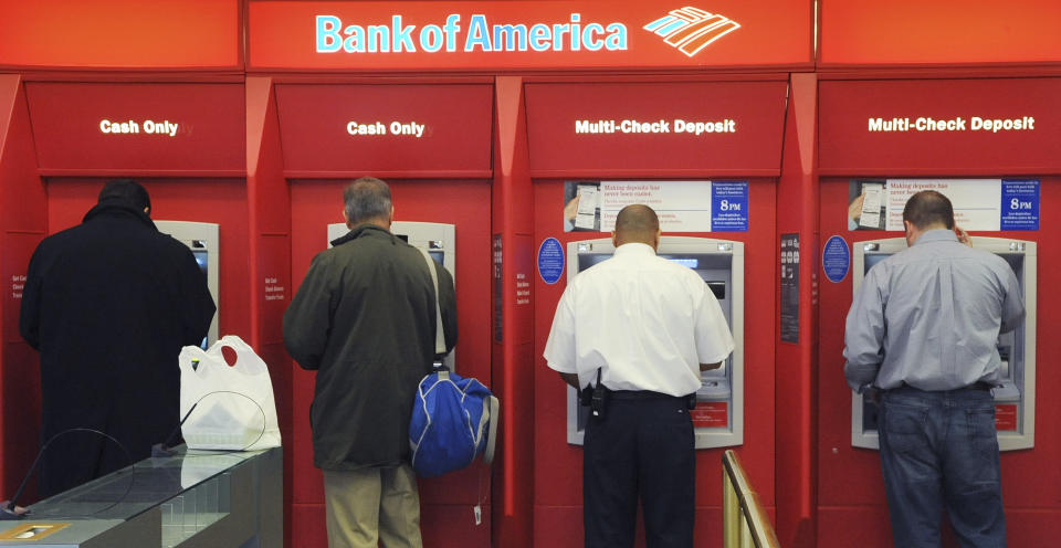 FILE - In this Oct. 16, 2009 file photo, customers use ATMs at a Bank of America branch office, Friday, Oct 16, 2009 in Boston. The Federal Reserve has issued a new rule that will prohibit banks from charging overdraft fees on ATM and debit card transactions unless a customer allows it. The new rule will take effect July 1, 2009. (AP Photo/Lisa Poole, file)