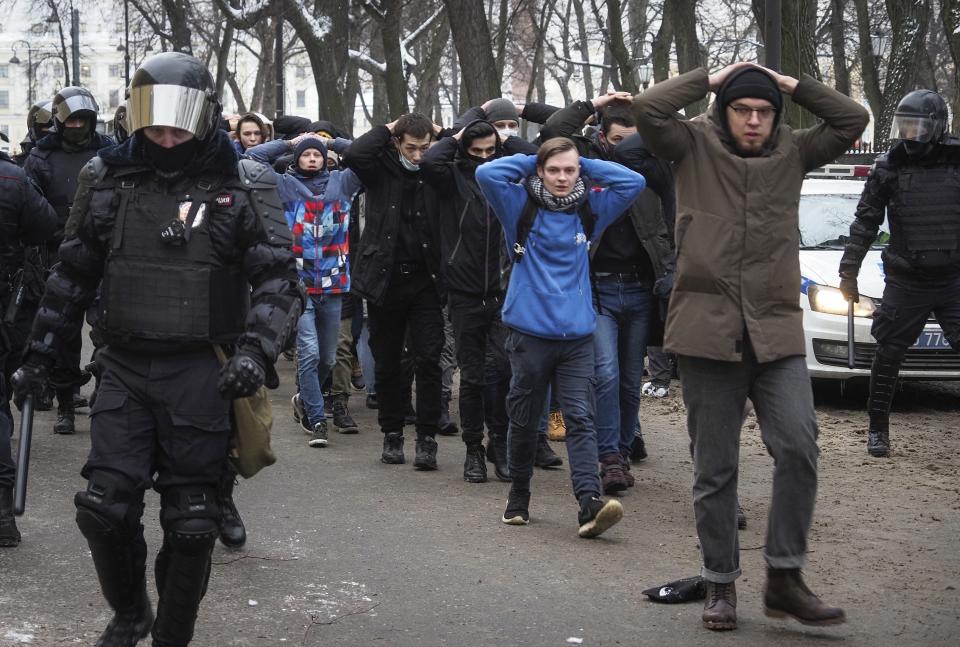 FILE - Detained protesters are escorted by police during a protest against the jailing of opposition leader Alexei Navalny in St. Petersburg, Russia, on Jan. 31, 2021. Memorial, Russia's oldest and most prominent human rights organization and a 2022 Nobel Peace Prize laureate, counted 558 political prisoners in the country as of April -- more than three times higher than in 2018, when it listed 183. (AP Photo, File)