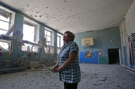 An employee stands in a damaged gymnasium at a school in the village of Spartak outside Donetsk, September 3, 2014. REUTERS/Maxim Shemetov