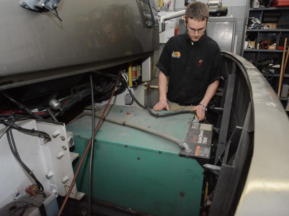 A person checking generator on a motor home.