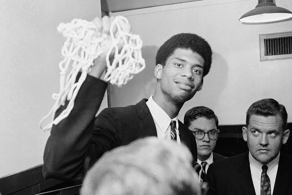 FILE - Lew Alcindor, later known as Kareem Abdul-Jabbar, still carrying part of net, talks with sports writers after he led UCLA to the NCAA championship on March 28, 1967 in Louisville, Ky. (AP Photo/File)