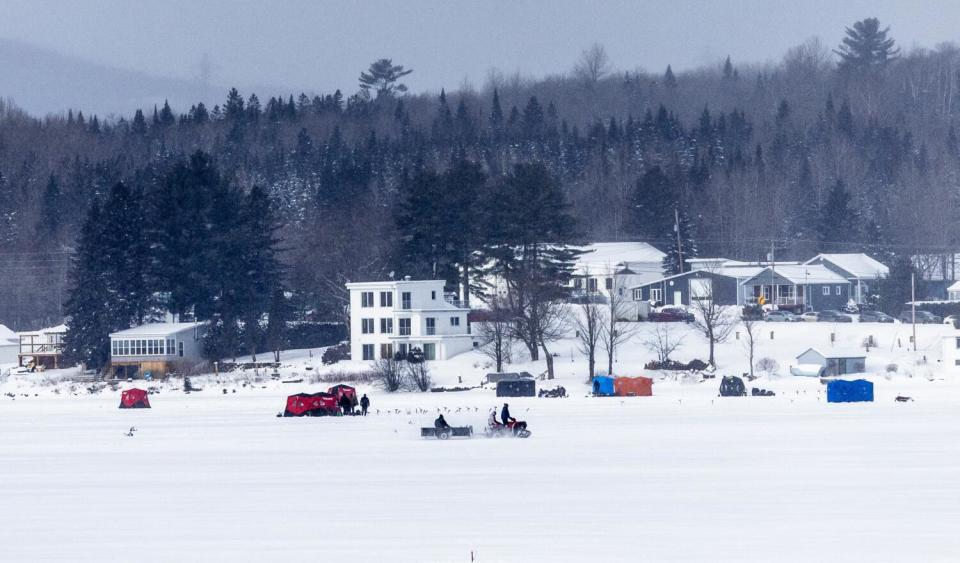 Ice fisherman and snowmobilers on the Canadian side of Lake Wallace as seen from the U.S. side.