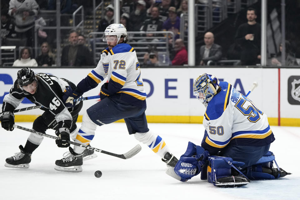 Los Angeles Kings center Blake Lizotte, left, tries to get a shot past St. Louis Blues goaltender Jordan Binnington, right, as defenseman Justin Faulk defends during the second period of an NHL hockey game Saturday, March 4, 2023, in Los Angeles. (AP Photo/Mark J. Terrill)